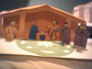 Kerststal van papier met figuren en een ster
