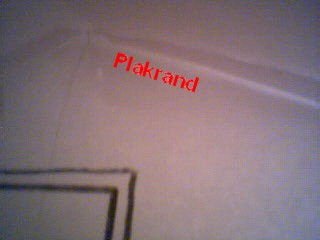 Close-up van een plakrand aan de bovenkant van een papieren wand